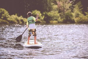 junge beim Stand-Up-Paddling (SUP) in schwimmweste